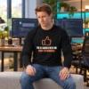AI Agreed With Me Long Sleeve Shirt Seated model wearing a black “The AI agreed with me. Now I’m worried.” long sleeve shirt with an orange thumbs-up graphic.